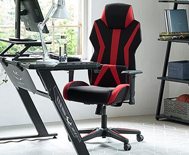 Fekete-piros gamer szék számítógépasztal előtt 