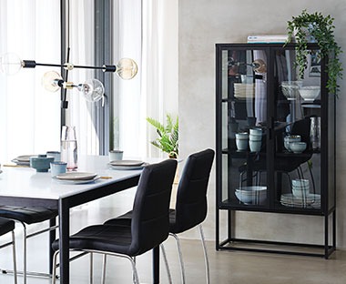 Fekete vitrin a modern étkezőben fekete székekkel és asztallal