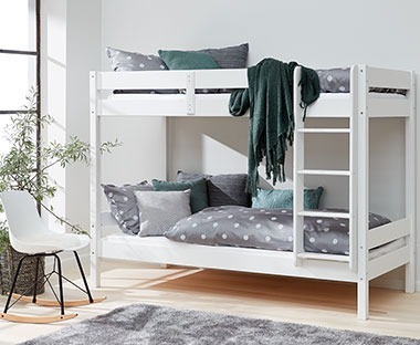 Fehér emeletes ágy szürke és sötétzöld ágyneművel