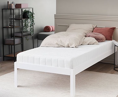 Minőségi fehér szivacs matrac ágyon világos mintás ágyneművel