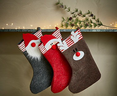 HIMINROD filcből készült szürke, piros és barna karácsonyi zoknik felakasztva