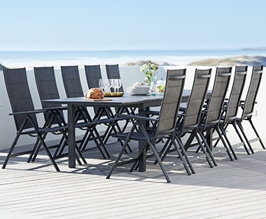 fekete kültéri asztal székekkel tengerparton