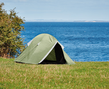 Zöld és szürke sátor a füvön vízparton