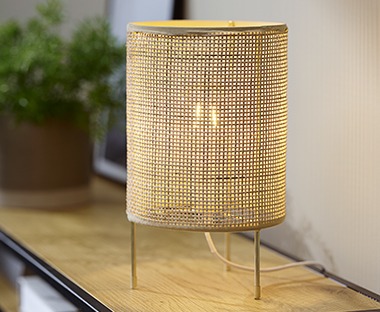 arany színű asztali lámpa polcon