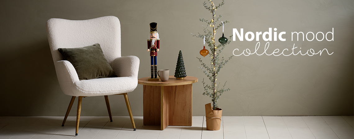 Fotel párnával, sarokasztal Karácsonyi figurával és vékony karácsonyfa üveg díszekkel díszítve 