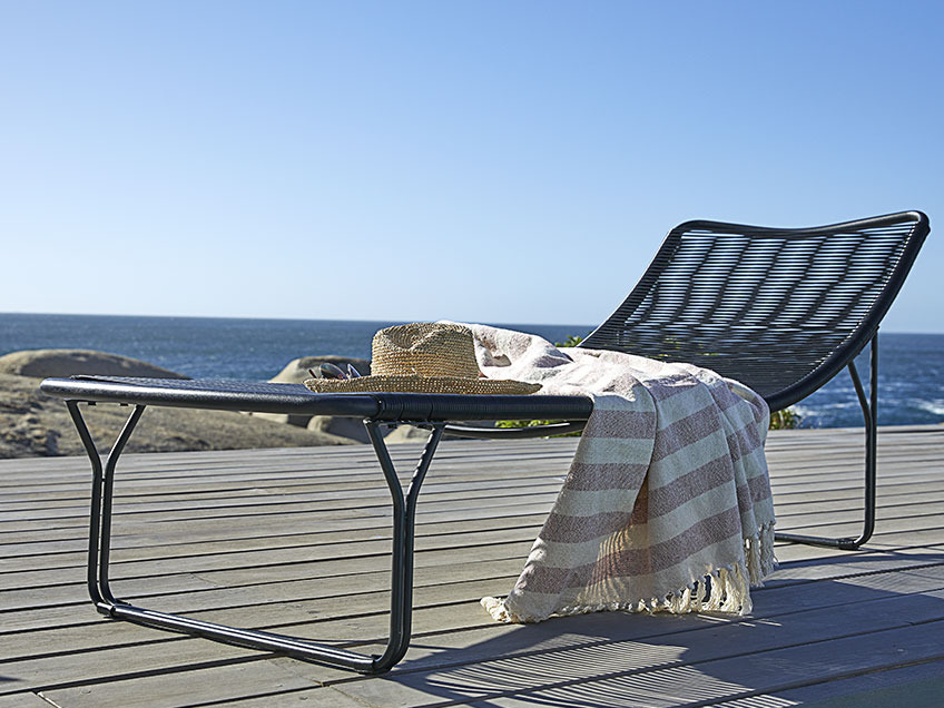 Sun lounger on a wooden patio by the ocean