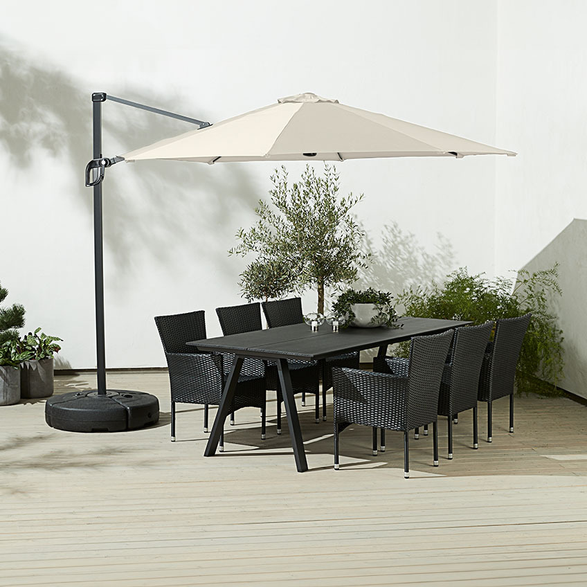 Nagyméretű, szögletes törtfehér függő napernyő egy kültéri étkezőasztal és kerti székek fölött