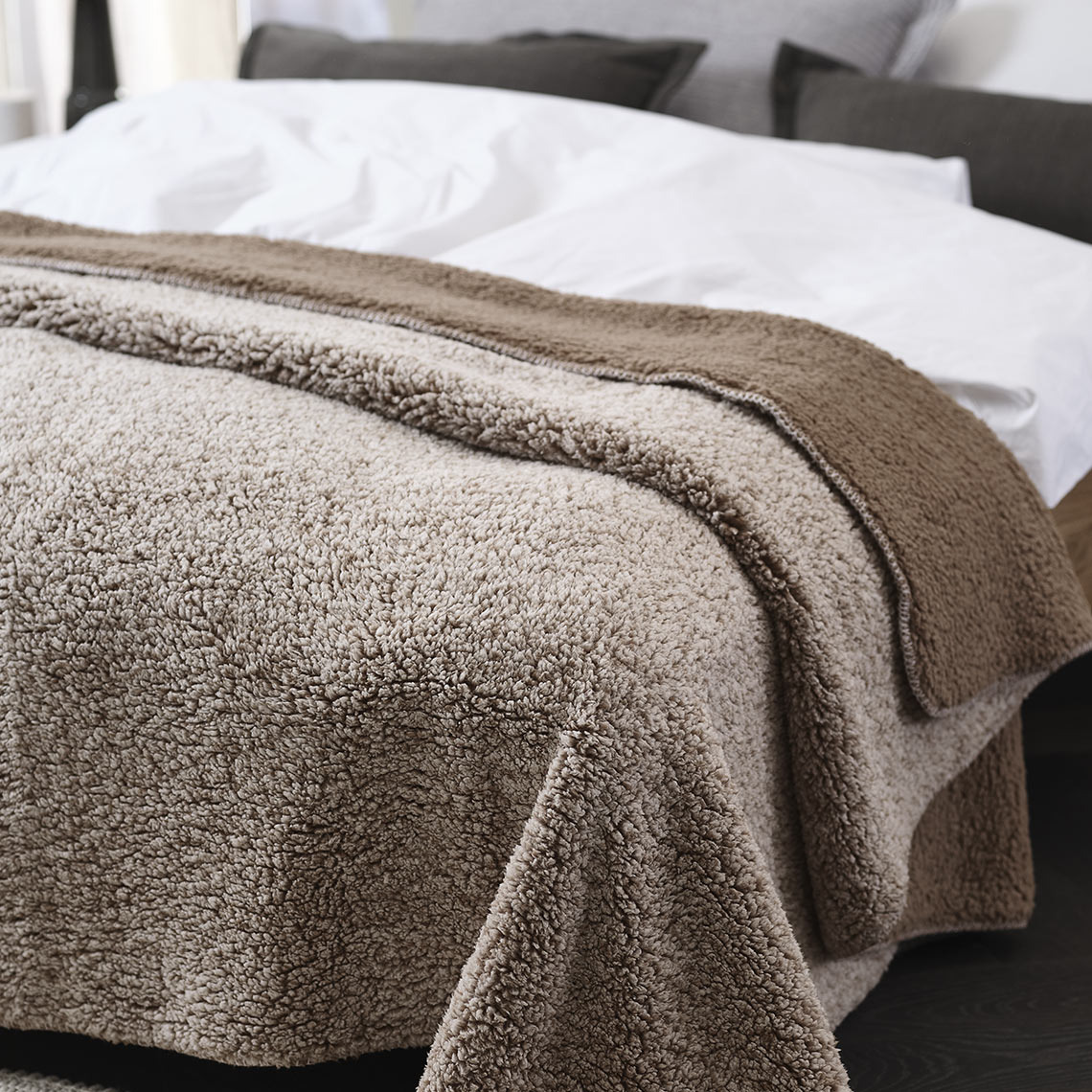 Barna polár pléd az ágyon a hálószobában