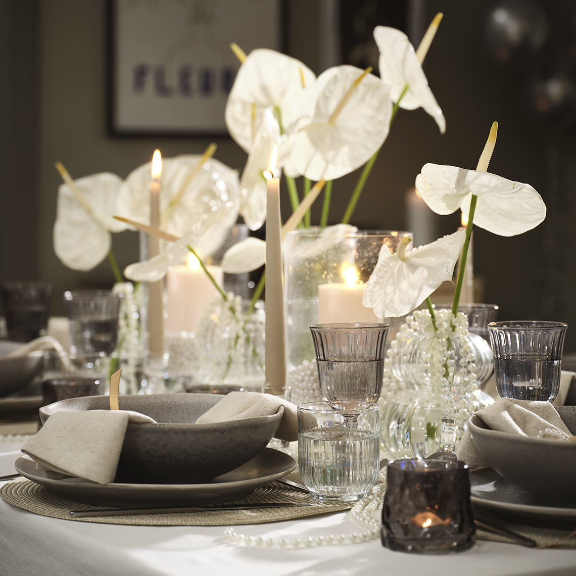 Asztalteríték tálakkal, tányérokkal, poharakkal és mécsestartókkal