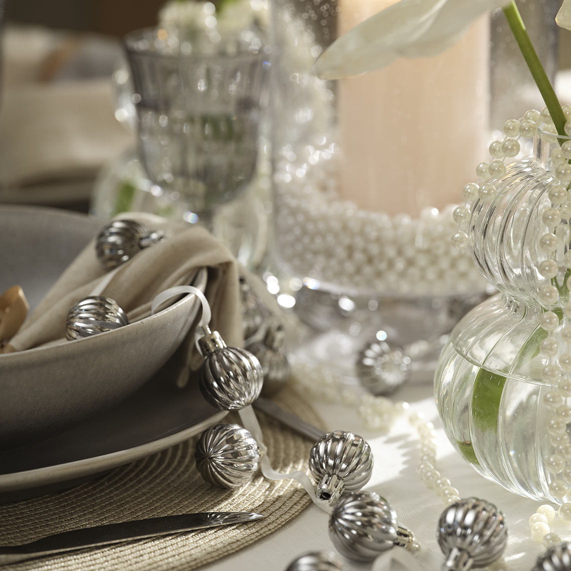 Karácsonyi gömbök füzéren a vacsoraasztalon