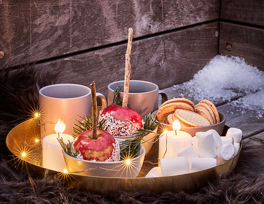 Karácsonyi asztali díszek, bögrék elegáns aranyszínű tálcán egyéb karácsoyni dekorációkkal