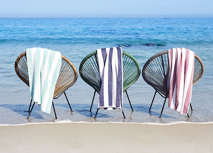 Kerti székek a strandon nagy csíkos strandtörülközőkkel a támlákon