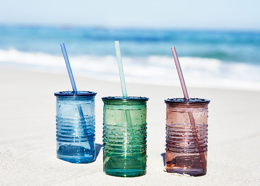 Három színes ivópohár tengerparton a strandon