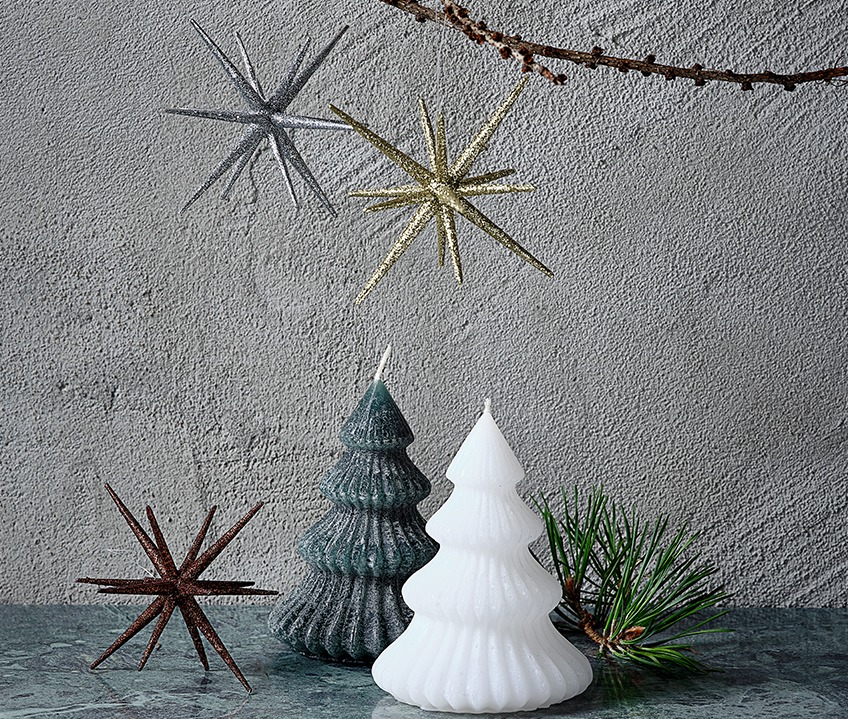Karácsonyfa formájú gyertyák és karácsonyi csillagok arany, ezüst és fehér színekben.