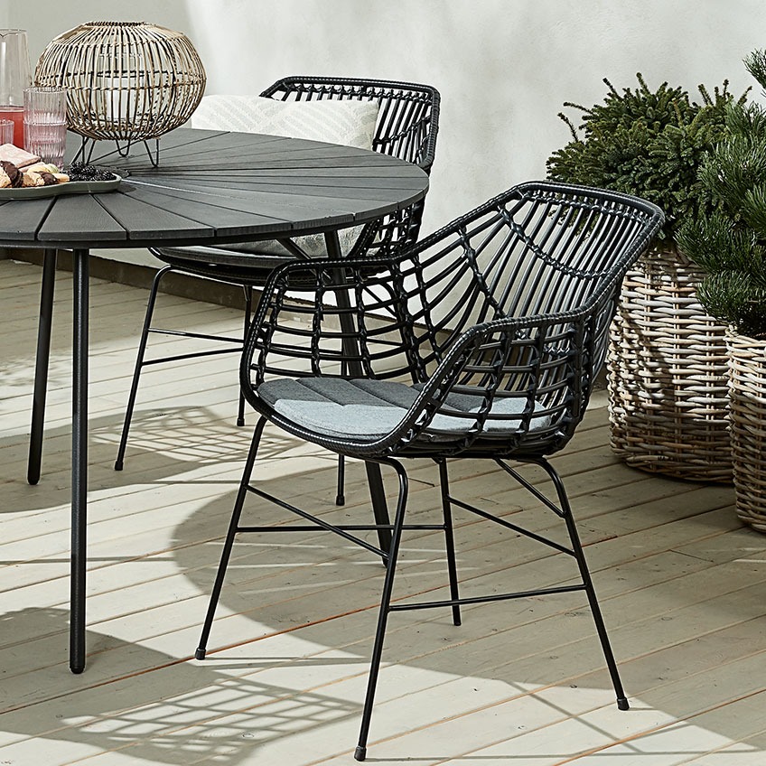 Fekete polyrattan kerti szék kerek kerti asztallal a teraszon