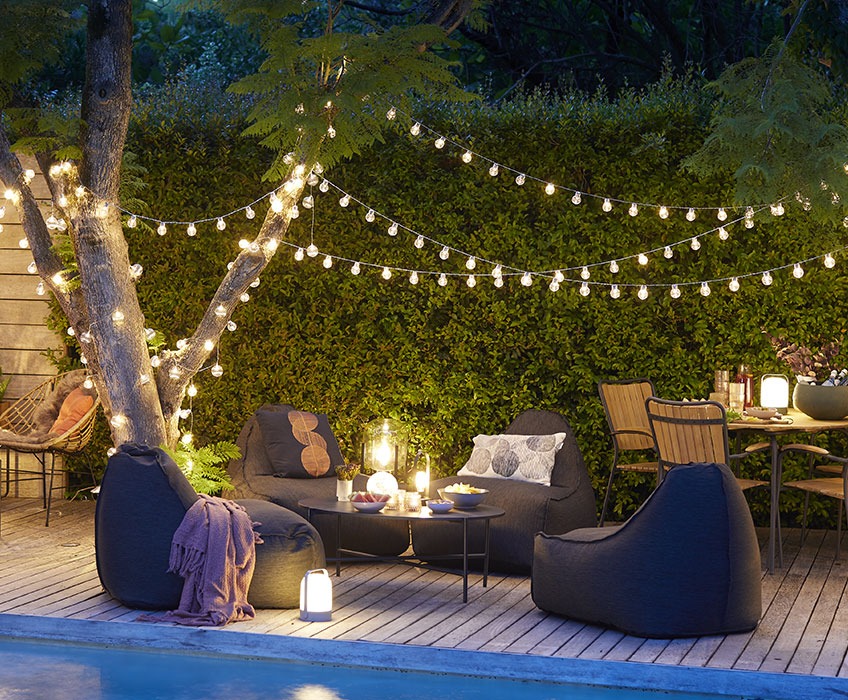 Outdoor setting with string lights, garden furniture and lanterns