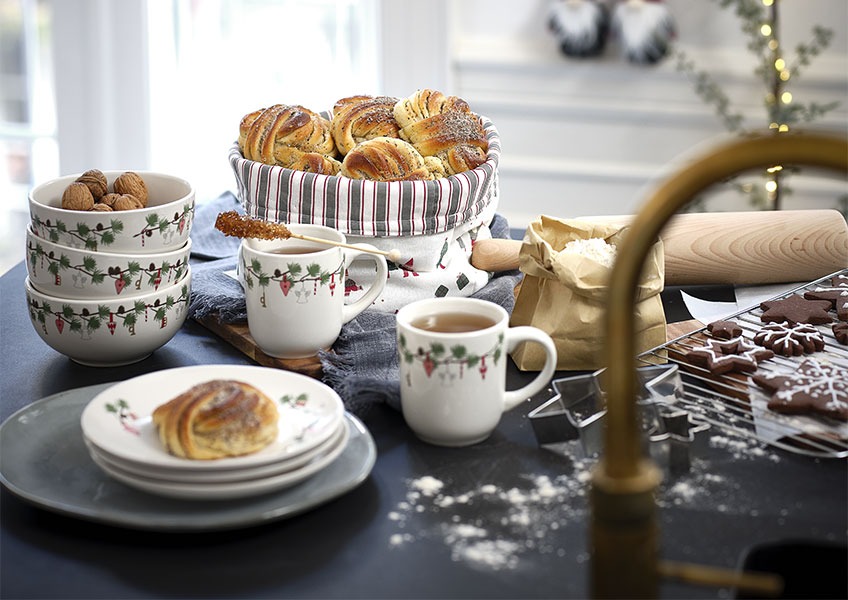 Tálak, bögrék és tányérok karácsonyi mintával és házi sütemények 