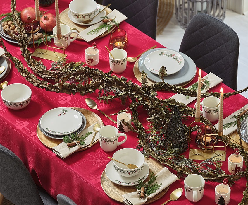 Karácsonyi vacsora terítés piros asztalterítővel és arany tányér 