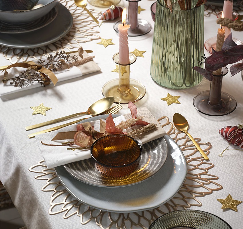 Szürke és kék tányérok aranyszínű evőeszközökkel egy Újévi ünnepséghez megterített asztalon