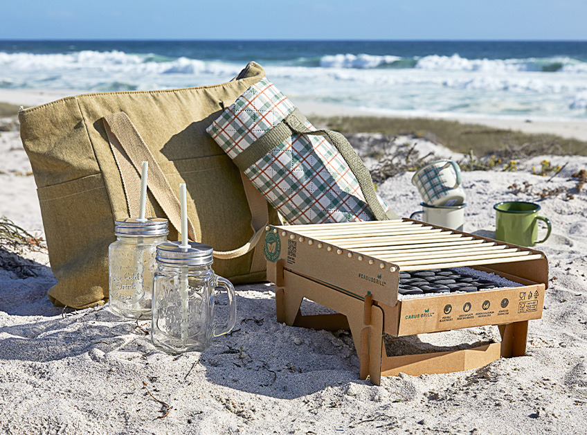 Egyszer használatos grill, hűtőtáska piknikhez, piknik pokróc, pohár és bögrék egy tengerparton