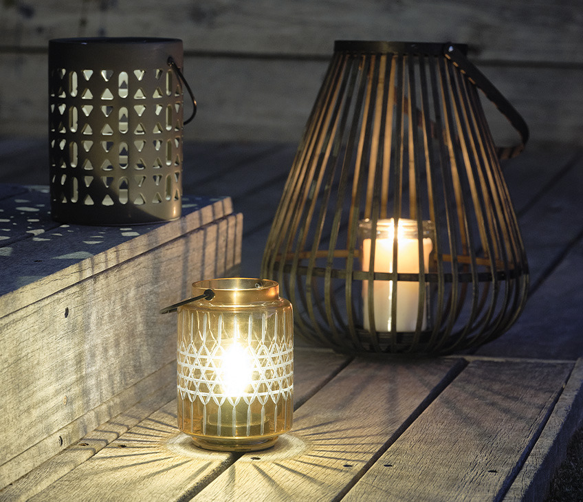 Garden lantern, solar garden light, and battery lamp radiating cosy, warm light on patio