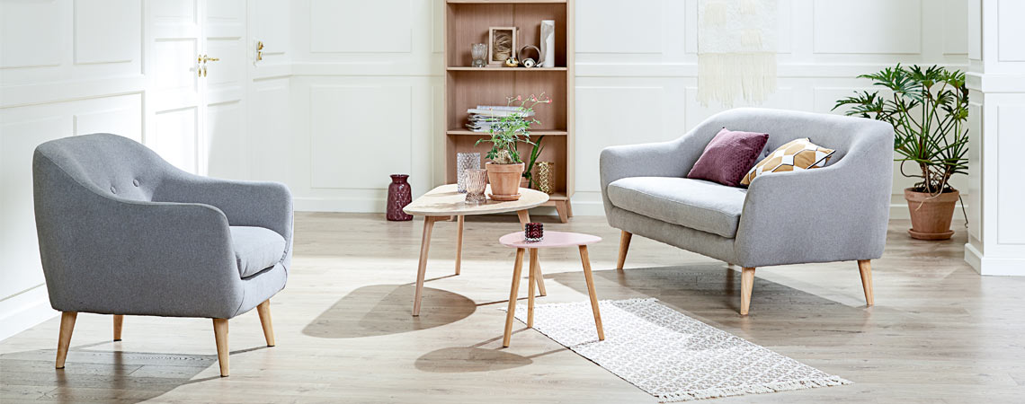 Elegáns szürke fotel kanapéval és asztalokkal a nappaliban